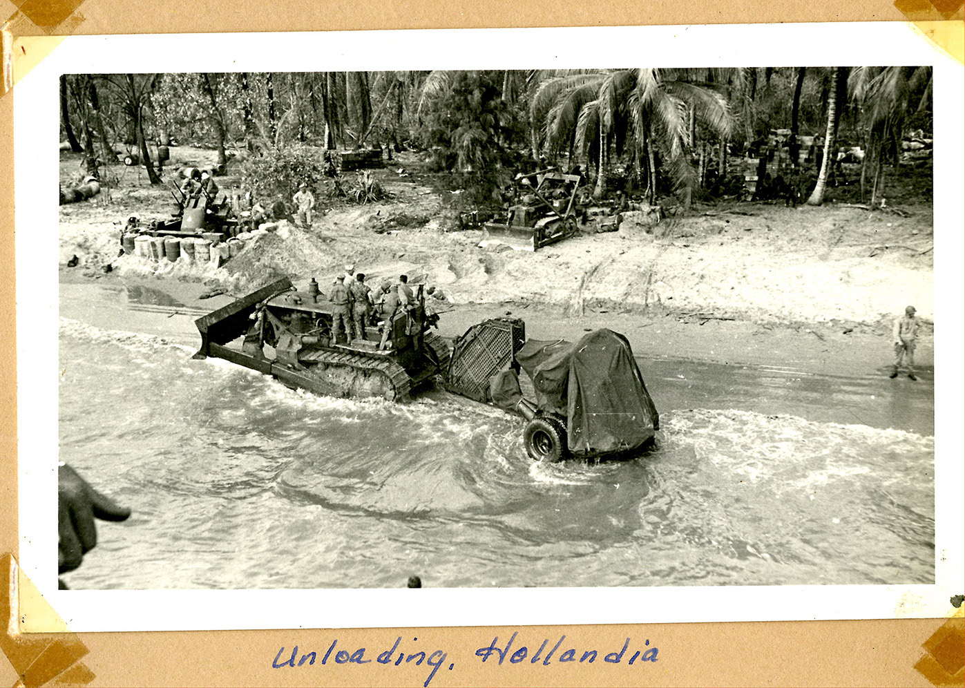 overhead view of men on a bulldozer in shallow water