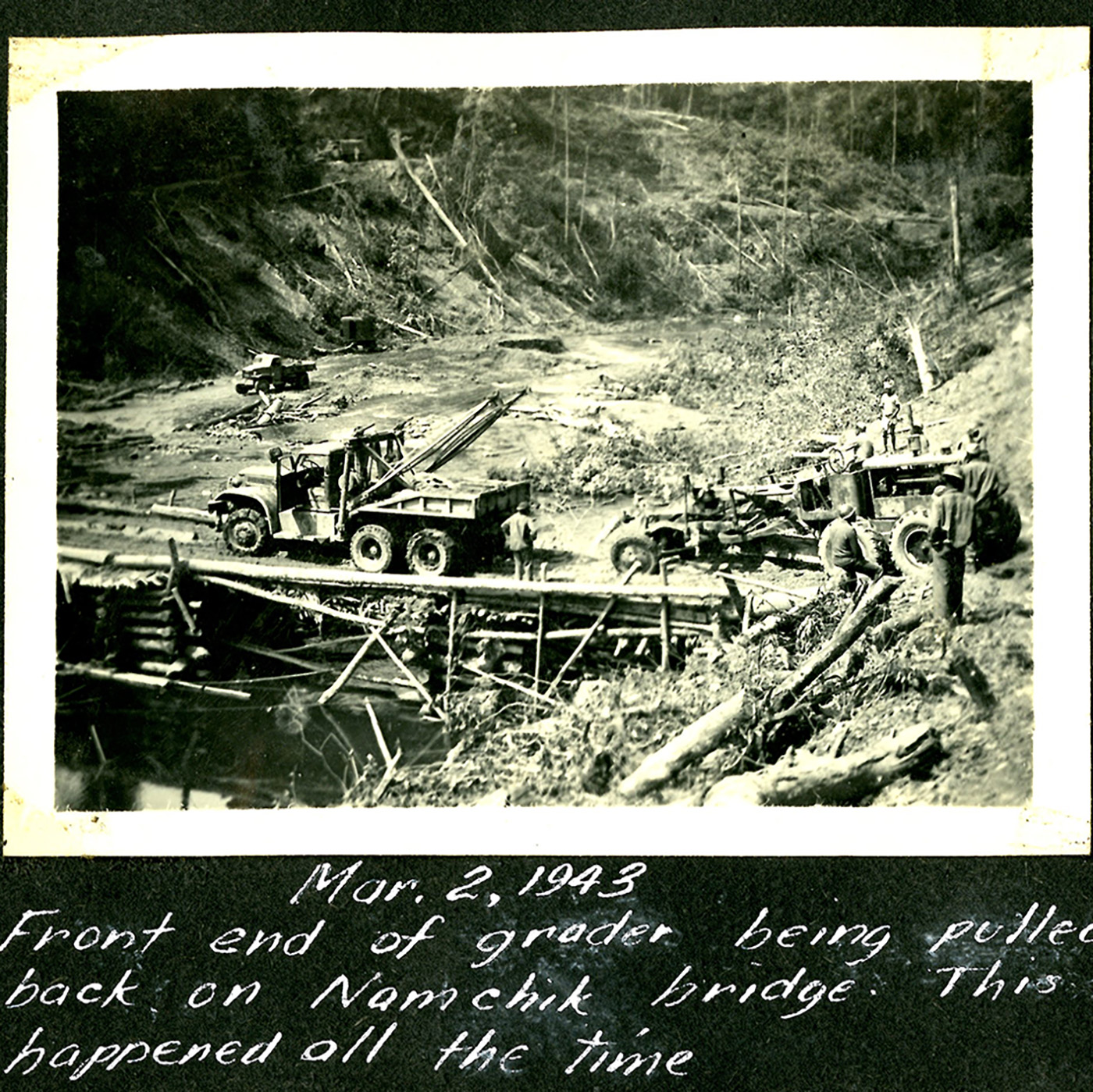 heavy equipment crossing a crude bridge