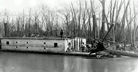 Boat pulling logs from a river