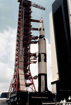 Positioned on its mobile launcher, a fully assembled Saturn V launch vehicle leaves the VAB.