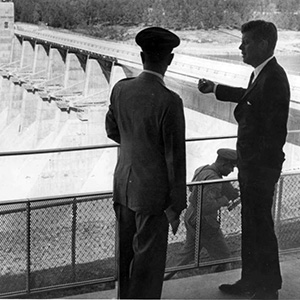 Maynard in uniform and Kennedy in suit at top of a dam