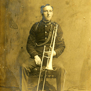 Young man in uniform sitting with a trombone