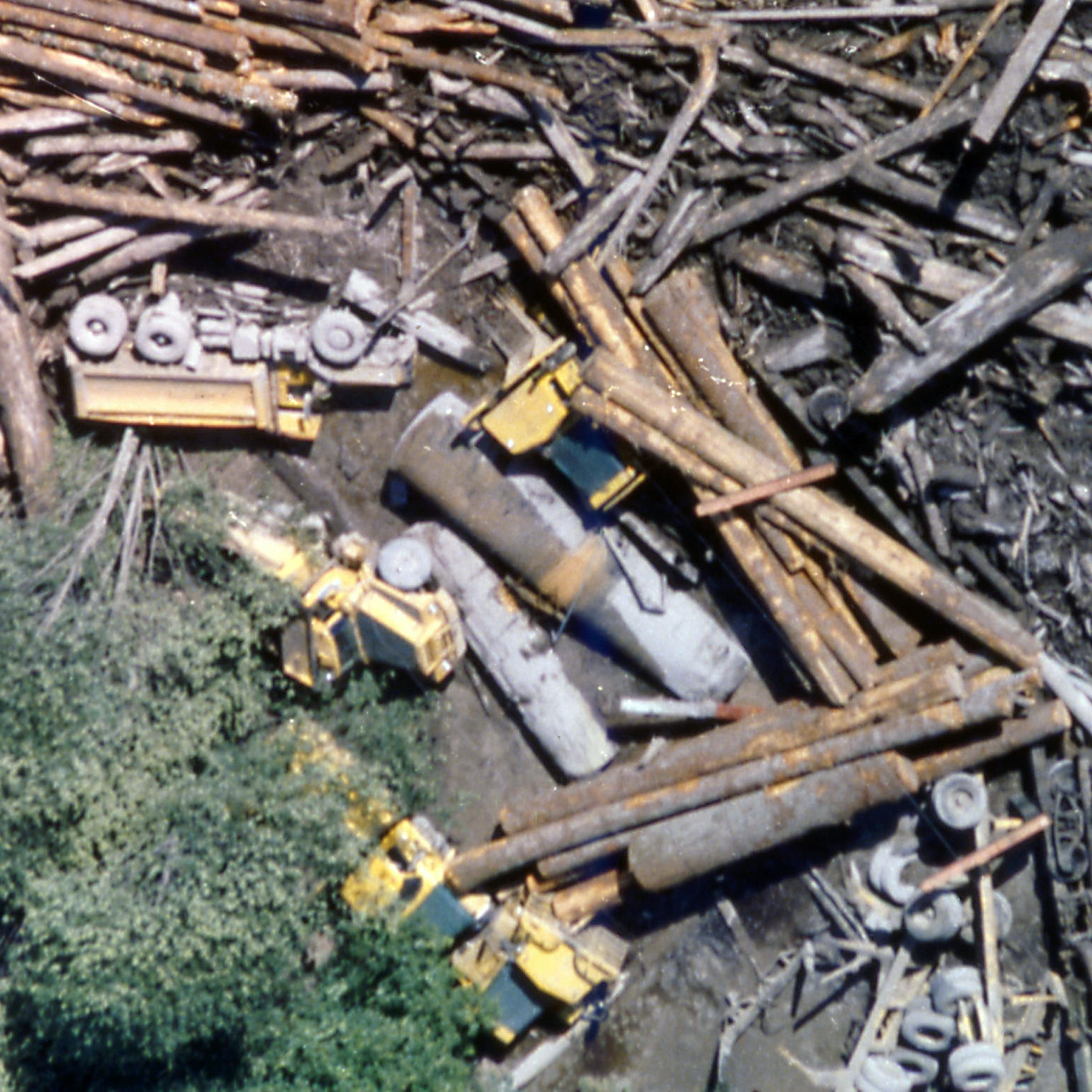 Overhead view of downed trees that have crushed heavy construction equipment