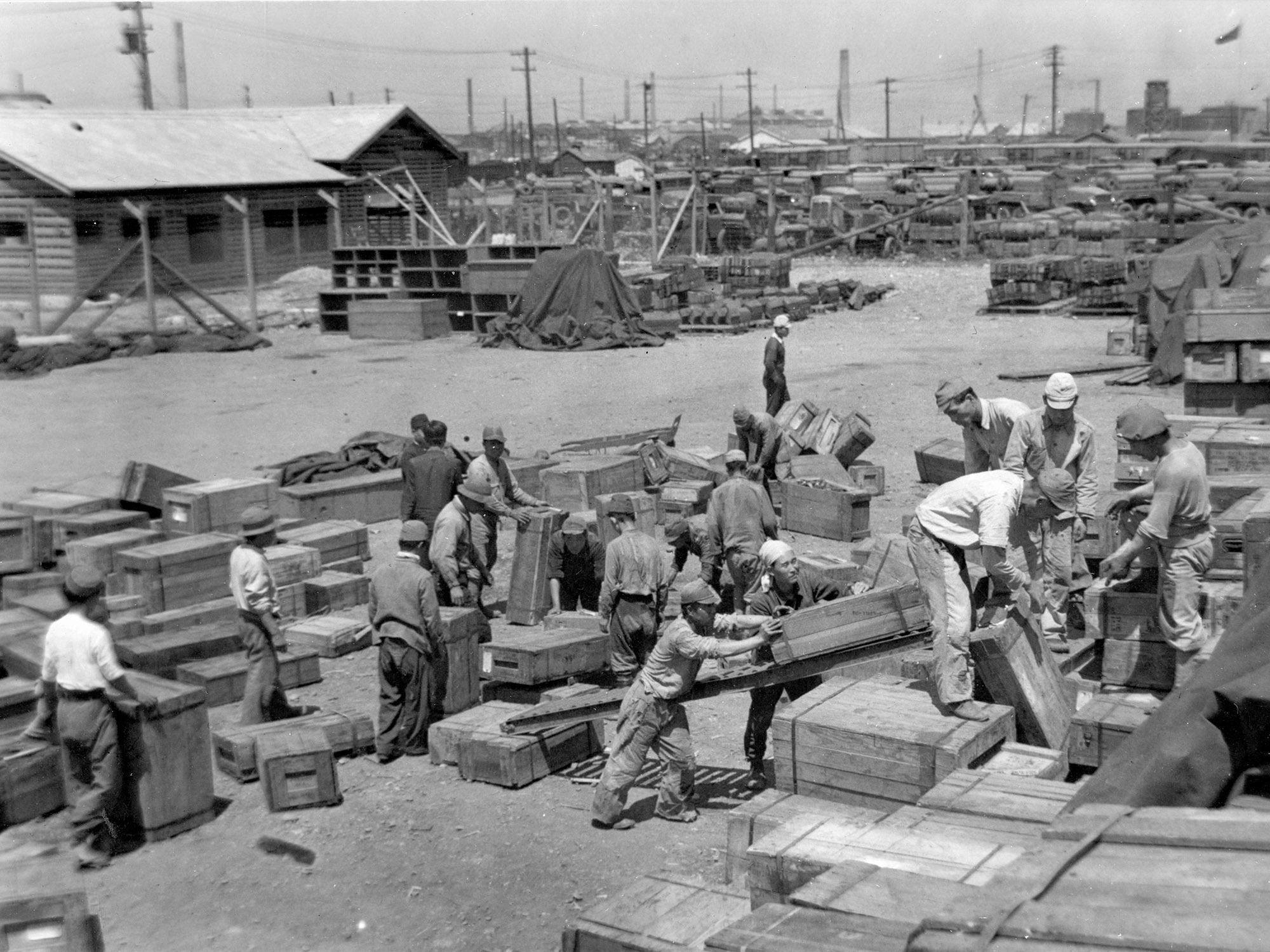 A dozen men moving boxes of supplies A dozen men moving boxes of supplies