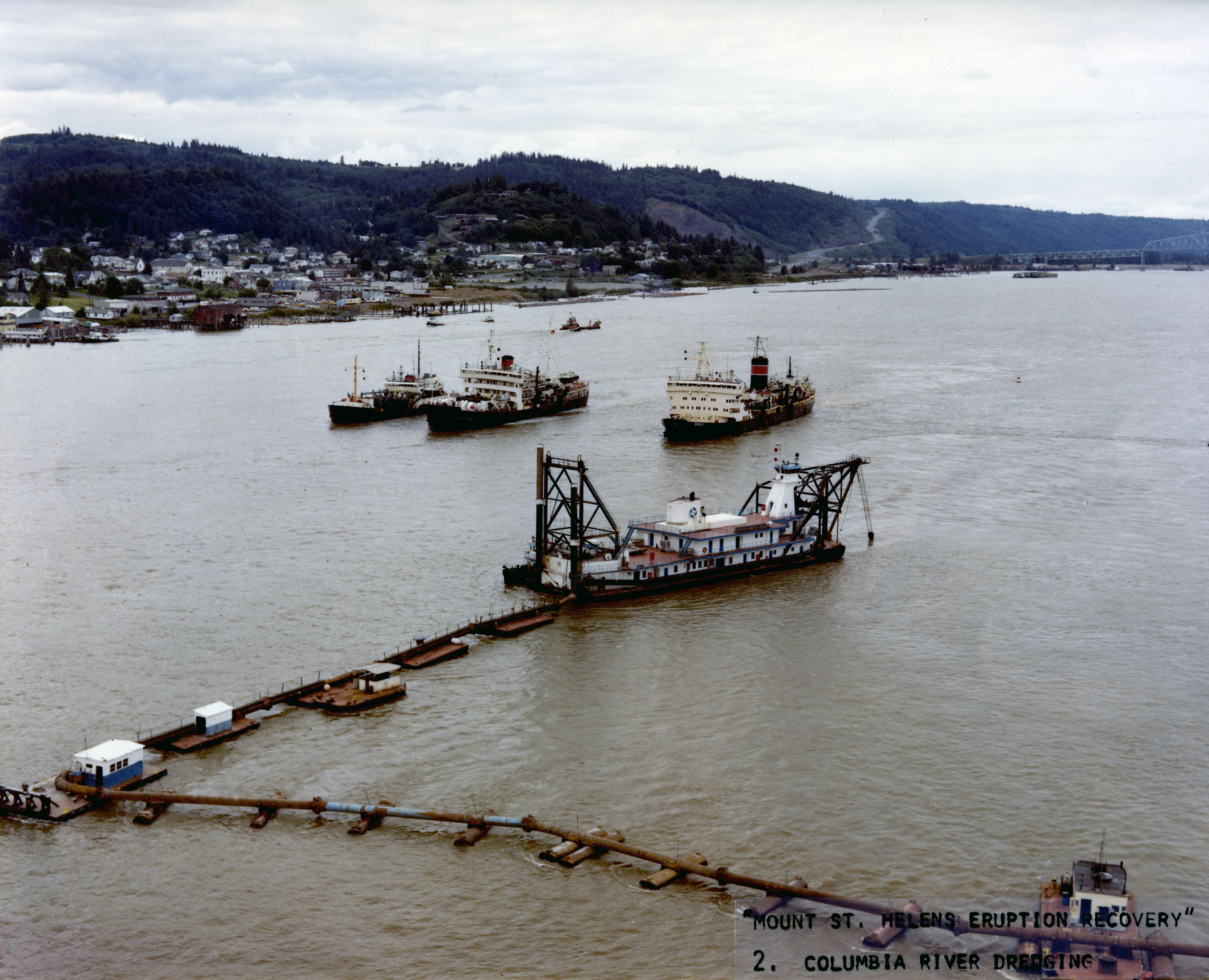 Dredge and other ships in the wide river