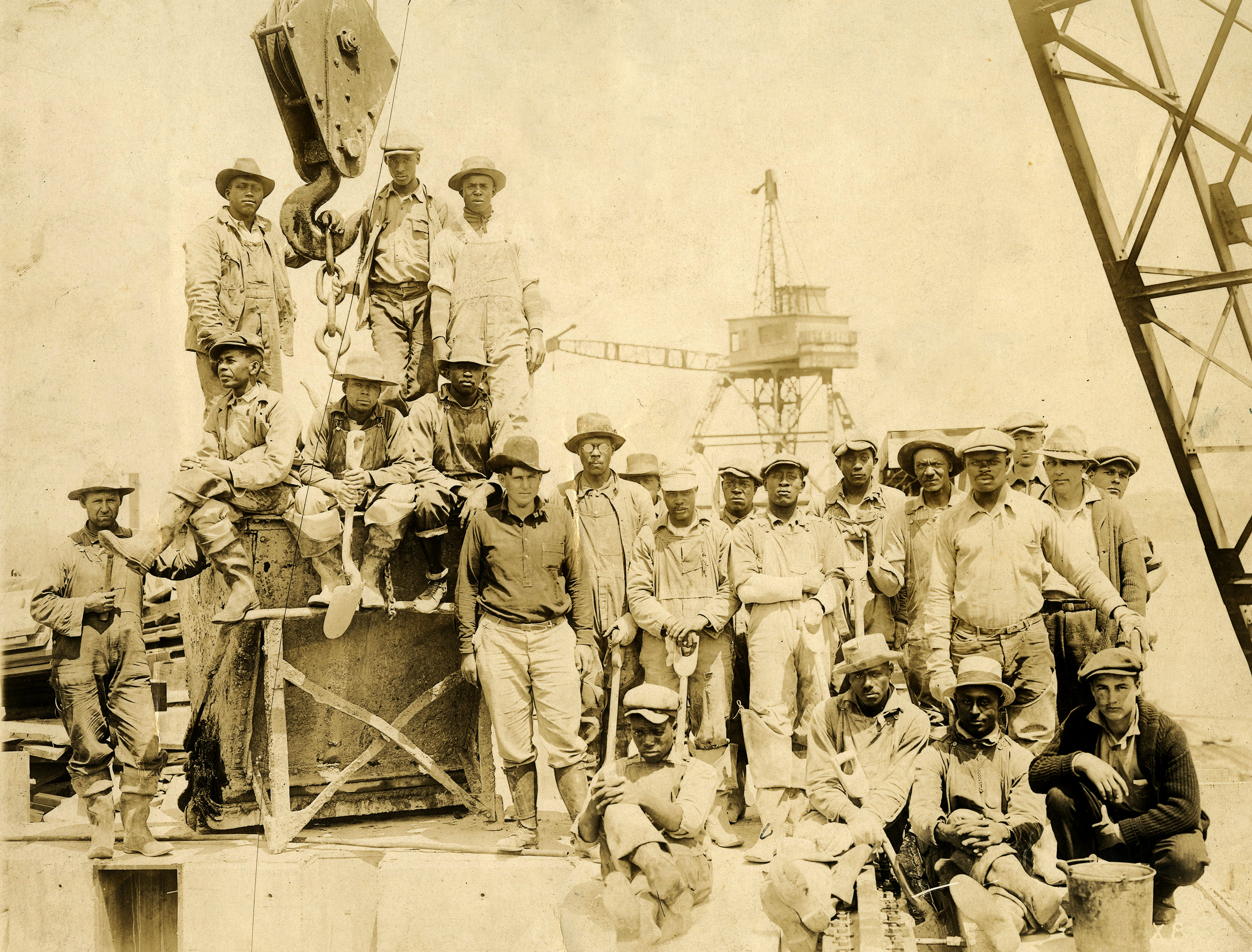 Several workers stand around heavy equipment