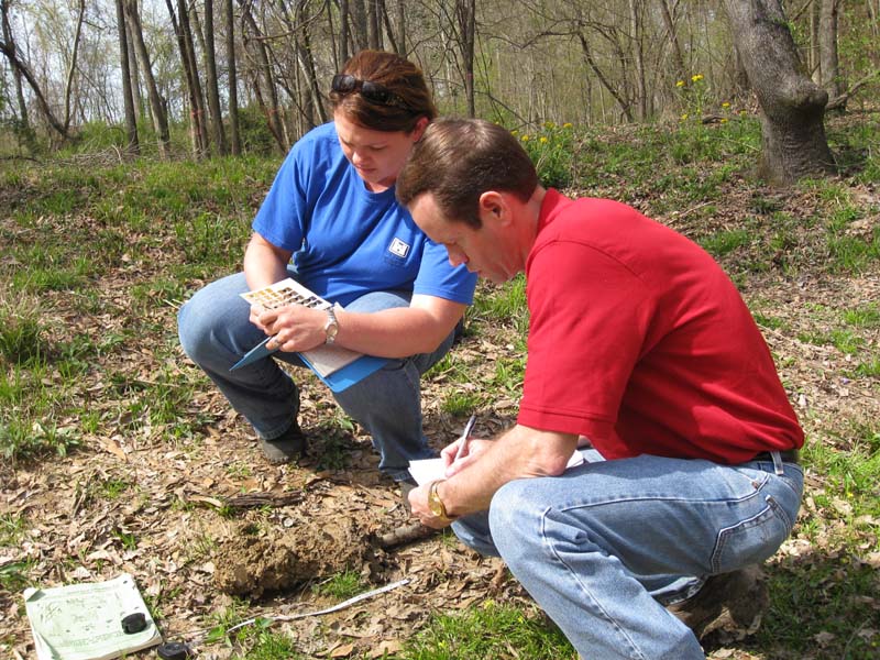 Man and woman checking soil conditions