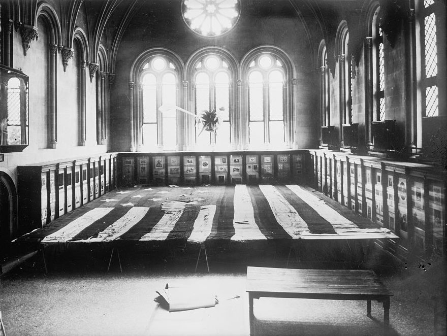 Flag that flew over Fort McHenry [in 1814], displayed horizontally in a room surrounded by cases, 4 June 1914.