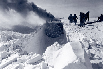 Machinery blowing snow and digging a tunnel