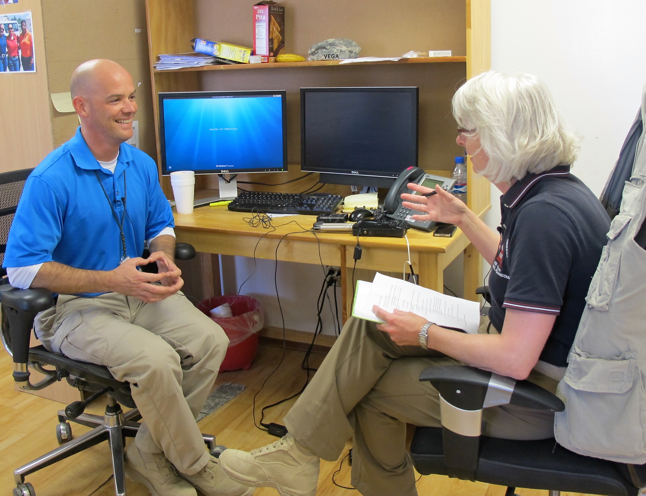 A woman is interviewing a man; both are sitting in an office A woman is interviewing a man; both are sitting in an office