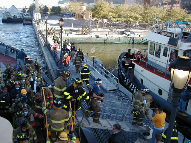 Firefighters getting off a boat and onto a pier