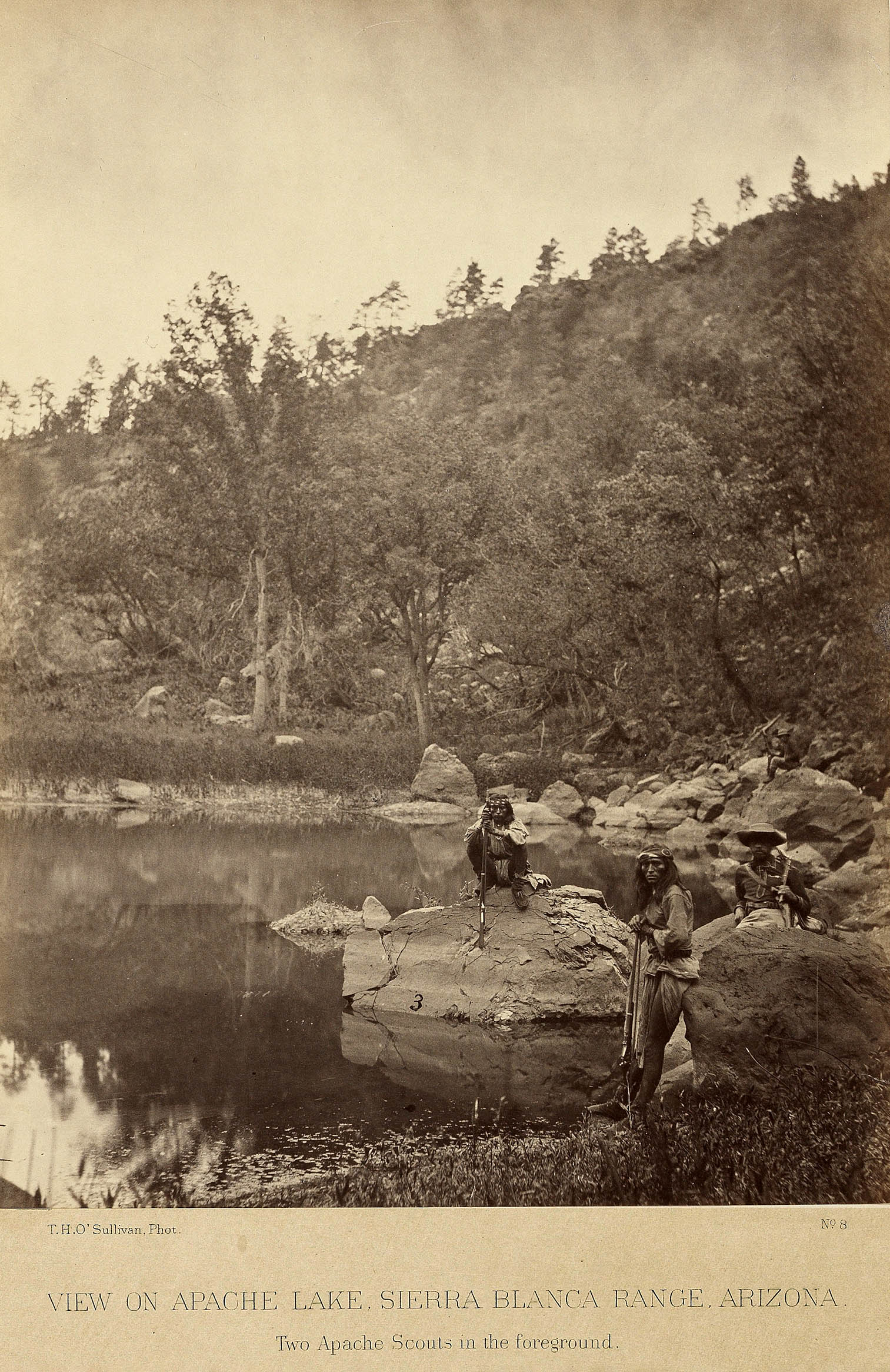  a lake with two men standing at shore